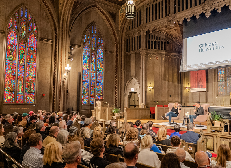 Audience looking at Ed Helms and Greta Johnsen talking on stage at First United Methodist Church